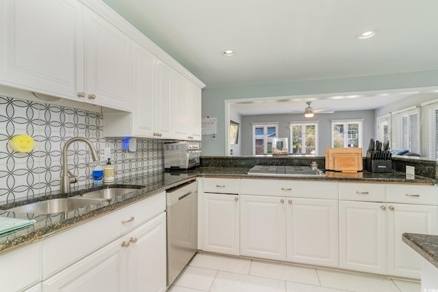 kitchen featuring backsplash, stainless steel appliances, white cabinetry, a ceiling fan, and a sink