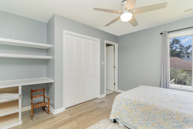 bedroom with visible vents, ceiling fan, baseboards, wood finished floors, and a closet