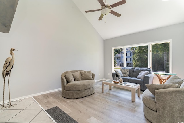 living room with baseboards, high vaulted ceiling, light wood-style floors, and ceiling fan