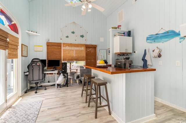 kitchen with ceiling fan, light wood-type flooring, and high vaulted ceiling