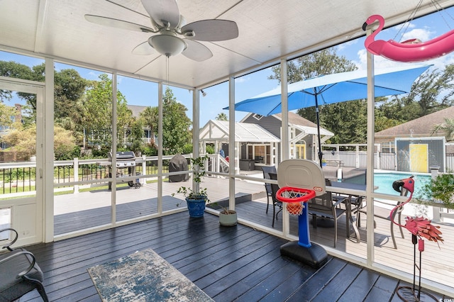 sunroom / solarium featuring plenty of natural light and a ceiling fan