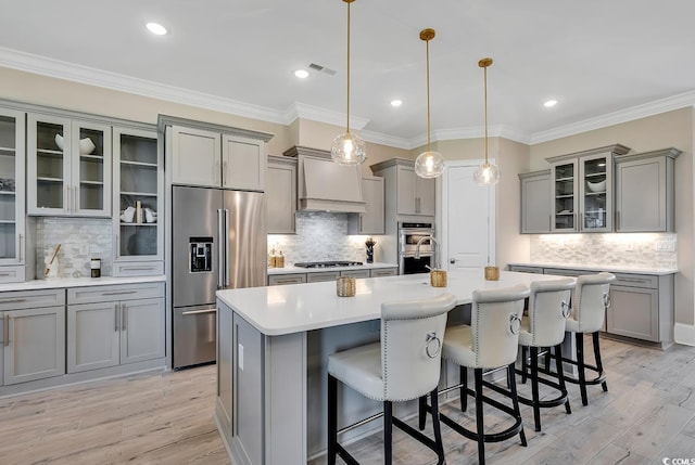 410 44th Ave N, Myrtle Beach, SC 29577 - kitchen featuring appliances with stainless steel finishes, gray cabinets, decorative backsplash, custom range hood, and ornamental molding