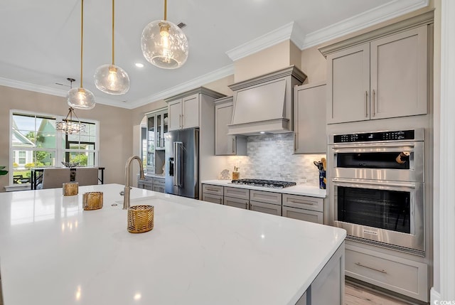 410 44th Ave N, Myrtle Beach, SC 29577 - kitchen with gray cabinets, appliances with stainless steel finishes, a chandelier, custom exhaust hood, and decorative backsplash