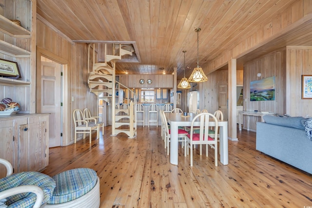 dining room featuring wooden ceiling, wood walls, hardwood / wood-style floors, and stairs