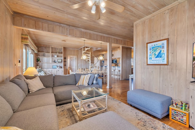 living area featuring wooden ceiling, wood finished floors, and wood walls