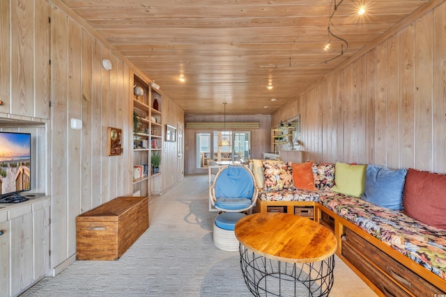 carpeted living area with wooden ceiling, wooden walls, and built in shelves