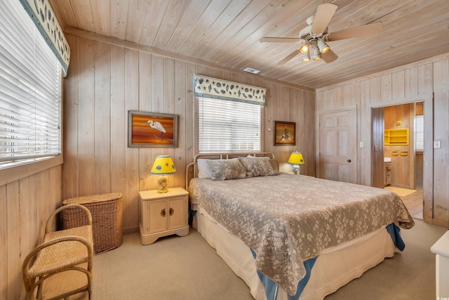 bedroom featuring light colored carpet, wood ceiling, and multiple windows