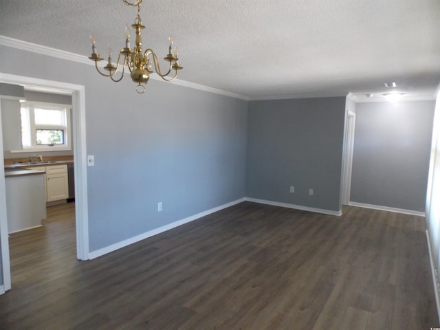 spare room featuring ornamental molding, a notable chandelier, dark wood finished floors, and baseboards