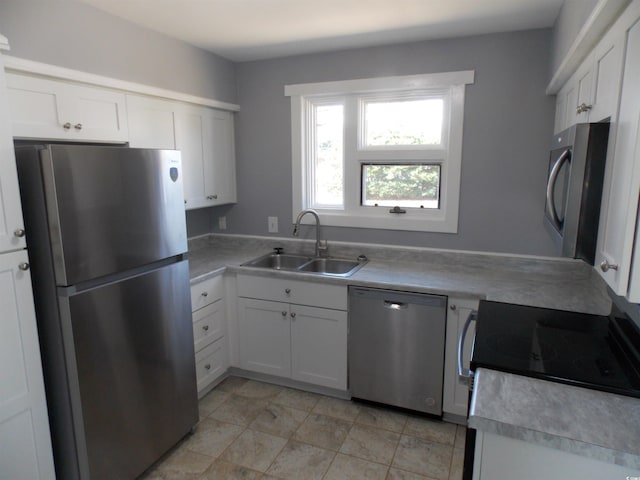 kitchen with appliances with stainless steel finishes, light countertops, white cabinets, and a sink