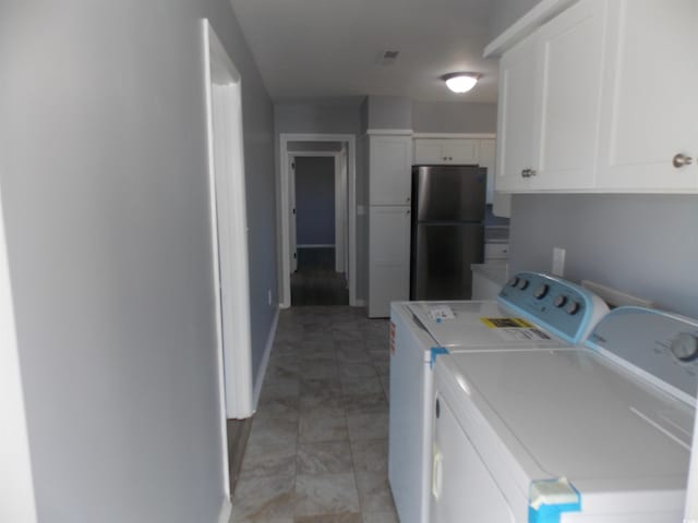 clothes washing area featuring baseboards and separate washer and dryer