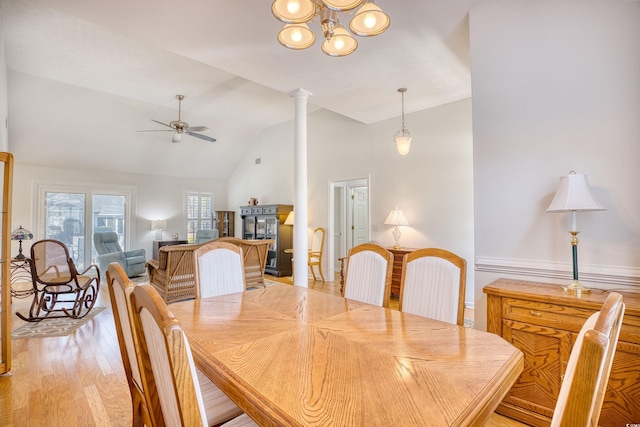 dining area with light wood finished floors, vaulted ceiling, ceiling fan, and decorative columns