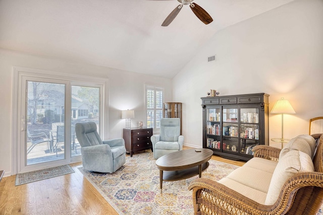 living room with visible vents, ceiling fan, baseboards, wood finished floors, and high vaulted ceiling