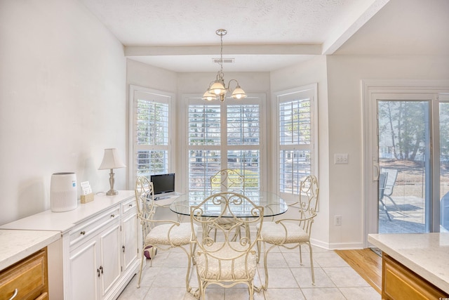 dining area with a wealth of natural light, visible vents, a textured ceiling, and a chandelier