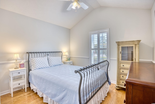 bedroom with ceiling fan, baseboards, light wood-style floors, and vaulted ceiling