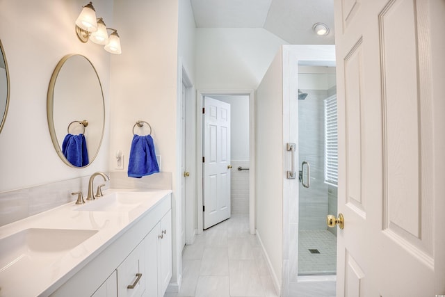 full bath with a sink, a stall shower, and double vanity