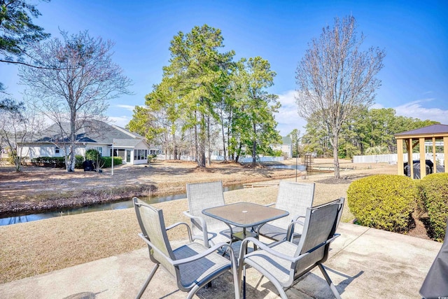 view of patio featuring a water view and outdoor dining space