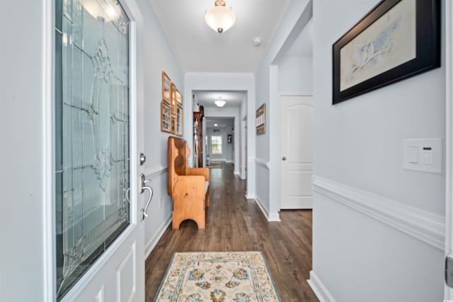 interior space with baseboards, dark wood-style flooring, and crown molding