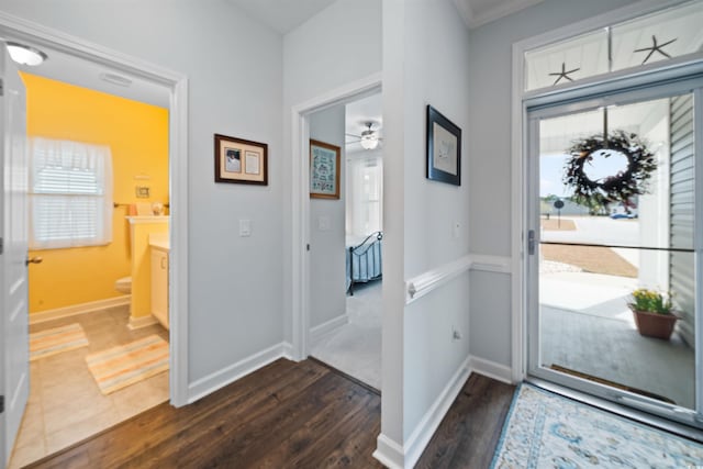 entryway with dark wood-type flooring, a healthy amount of sunlight, ceiling fan, and baseboards