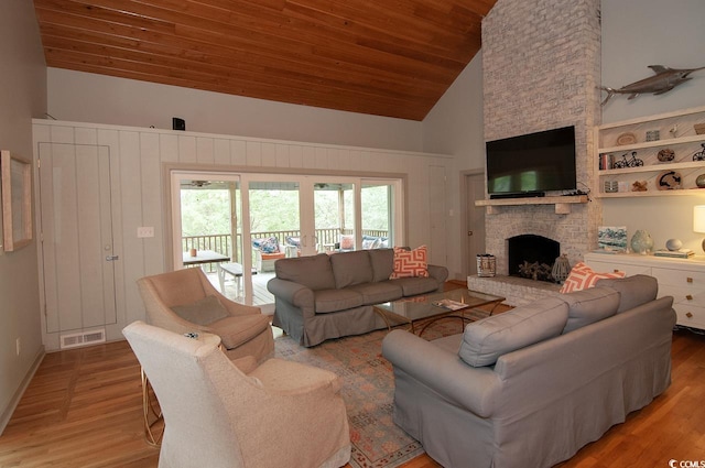 living area featuring visible vents, a fireplace, wood ceiling, and light wood-type flooring