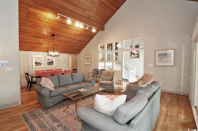 living area featuring high vaulted ceiling, wooden ceiling, rail lighting, light wood finished floors, and stairs