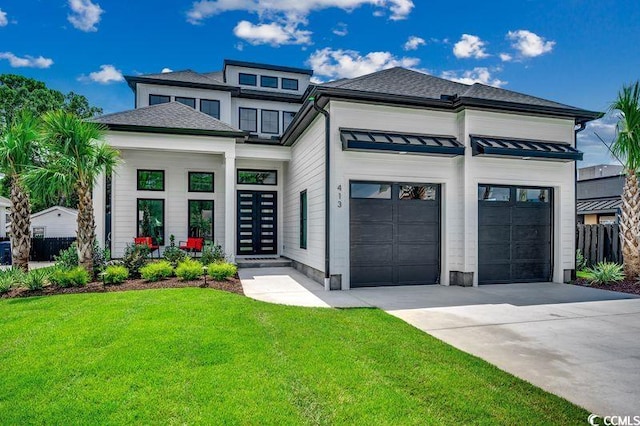 prairie-style home featuring metal roof, an attached garage, driveway, a standing seam roof, and a front yard