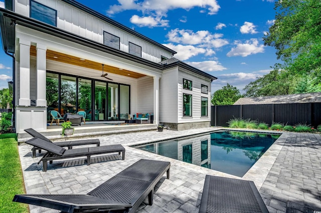 rear view of house with a fenced in pool, a patio, board and batten siding, fence, and ceiling fan