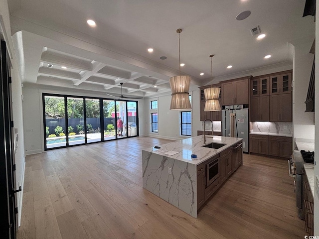 kitchen featuring stainless steel appliances, coffered ceiling, a sink, visible vents, and open floor plan