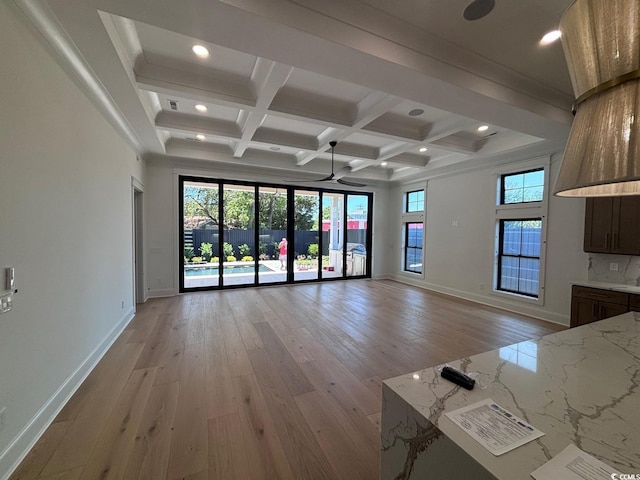 unfurnished living room featuring light wood finished floors, coffered ceiling, and beam ceiling