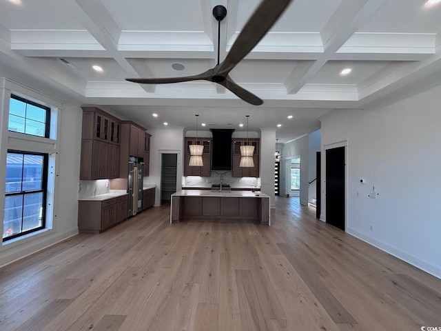 kitchen featuring plenty of natural light, coffered ceiling, decorative backsplash, and light wood-style floors