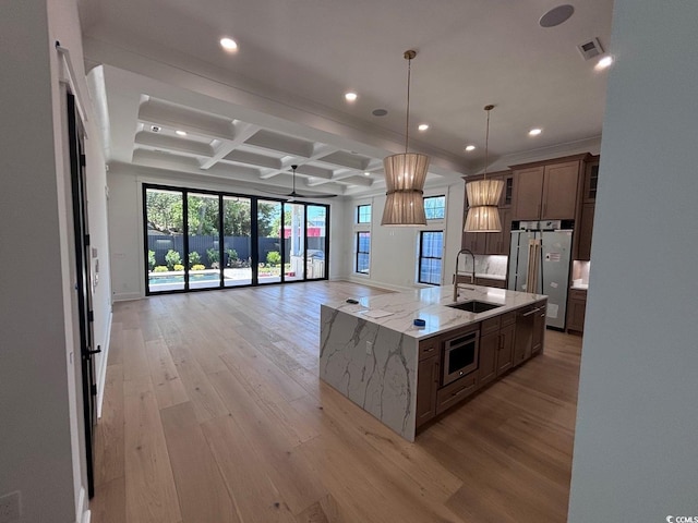 kitchen with coffered ceiling, a sink, visible vents, open floor plan, and fridge