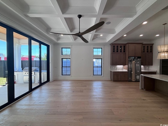 unfurnished living room featuring light wood-style floors, baseboards, coffered ceiling, and beamed ceiling