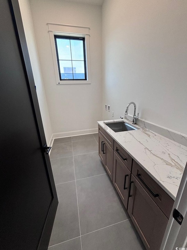 bathroom with vanity, baseboards, and tile patterned floors