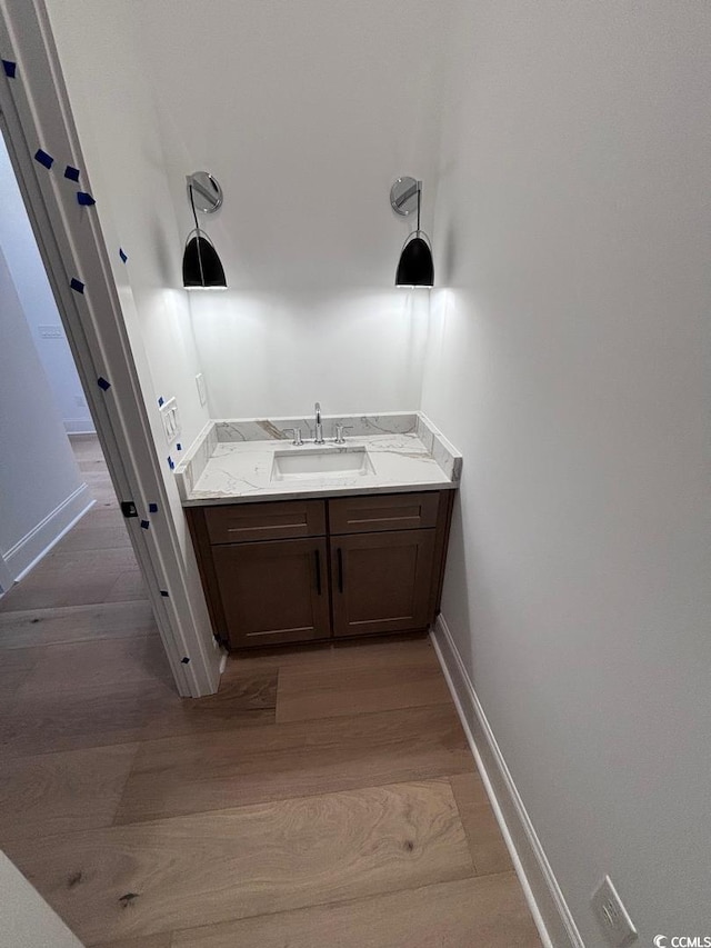 bathroom with vanity, baseboards, and wood finished floors