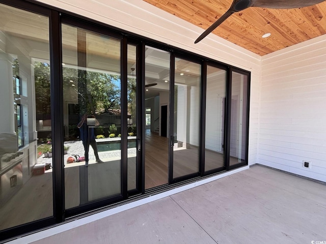 doorway to outside with concrete flooring and wood ceiling