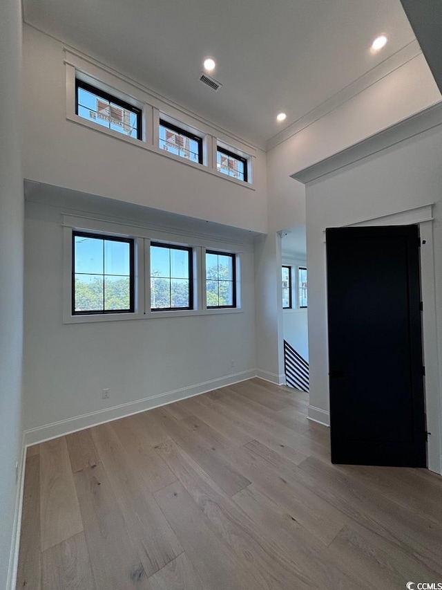 unfurnished room with plenty of natural light, light wood-style flooring, and baseboards