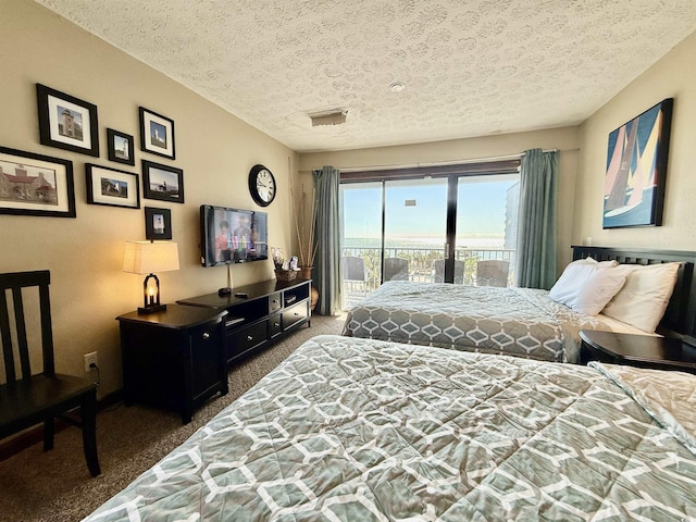 bedroom featuring access to exterior, carpet, and a textured ceiling