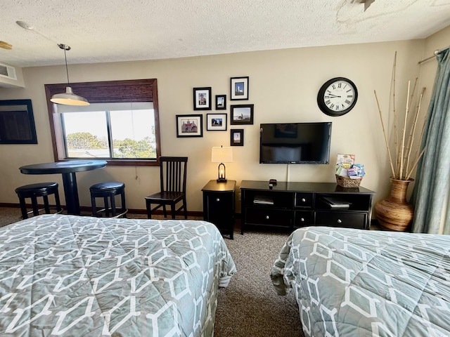 bedroom with carpet, visible vents, a textured ceiling, and baseboards