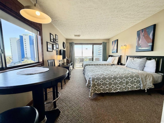 bedroom with a textured ceiling, carpet floors, and access to outside