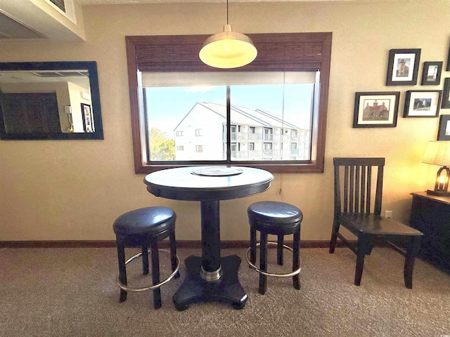 dining room featuring carpet flooring and baseboards