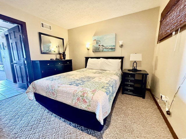 bedroom with a textured ceiling, carpet floors, visible vents, and baseboards