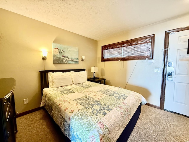 bedroom with a textured ceiling, carpet floors, and baseboards