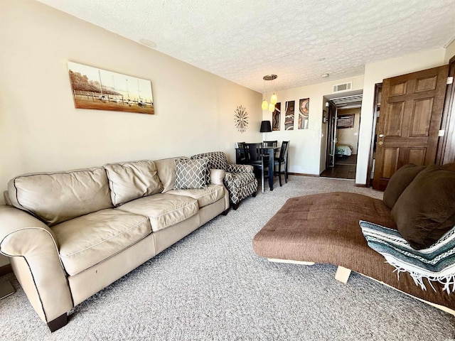 living area with a textured ceiling, visible vents, and carpet flooring