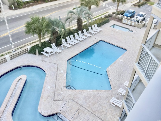 pool featuring a community hot tub and a patio area