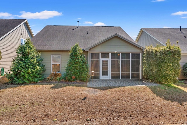 back of house featuring a shingled roof and a sunroom