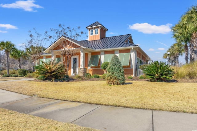 view of front of property featuring a standing seam roof, metal roof, and a front lawn