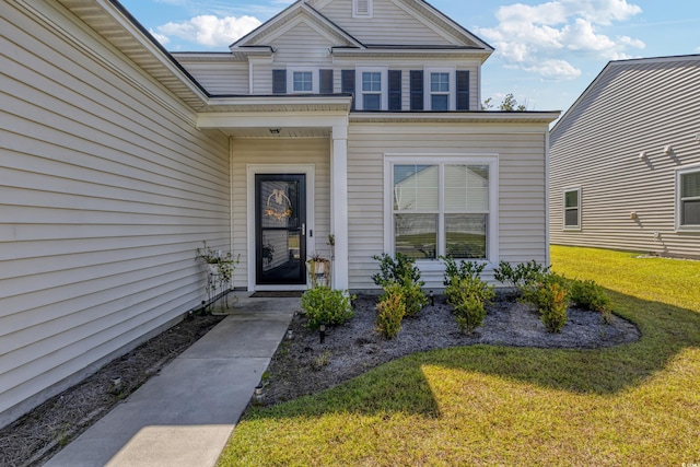 property entrance with a lawn