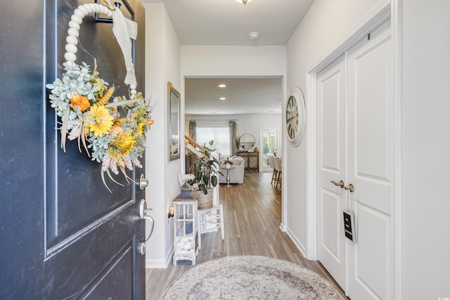 foyer entrance with recessed lighting, baseboards, and wood finished floors