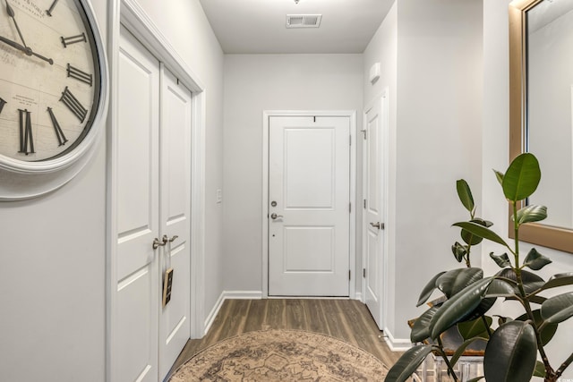 doorway to outside featuring dark wood-style floors, visible vents, and baseboards