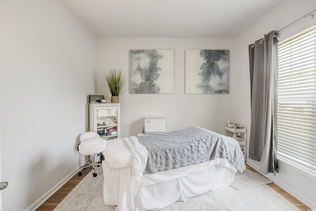 bedroom featuring wood finished floors and baseboards