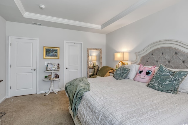 bedroom with a raised ceiling, visible vents, and crown molding